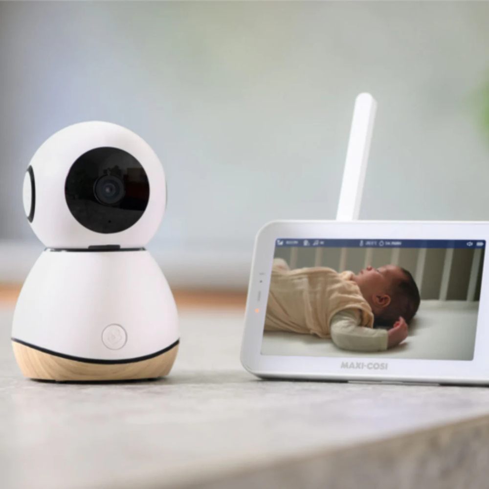 Baby monitor with camera and display showing a baby in a crib.

